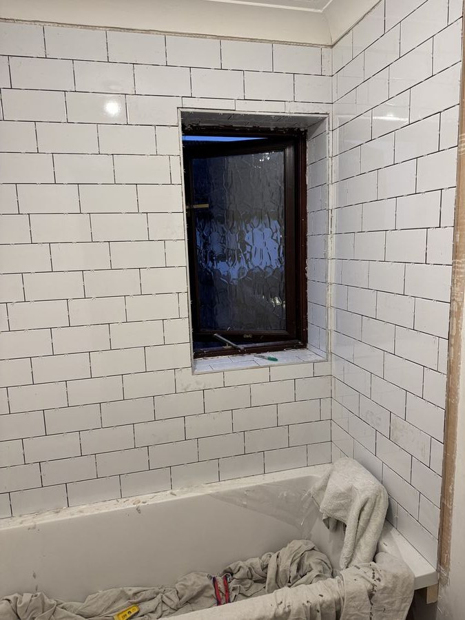 A tiled window reveal in a bathroom, the tiles returned neatly into the opening