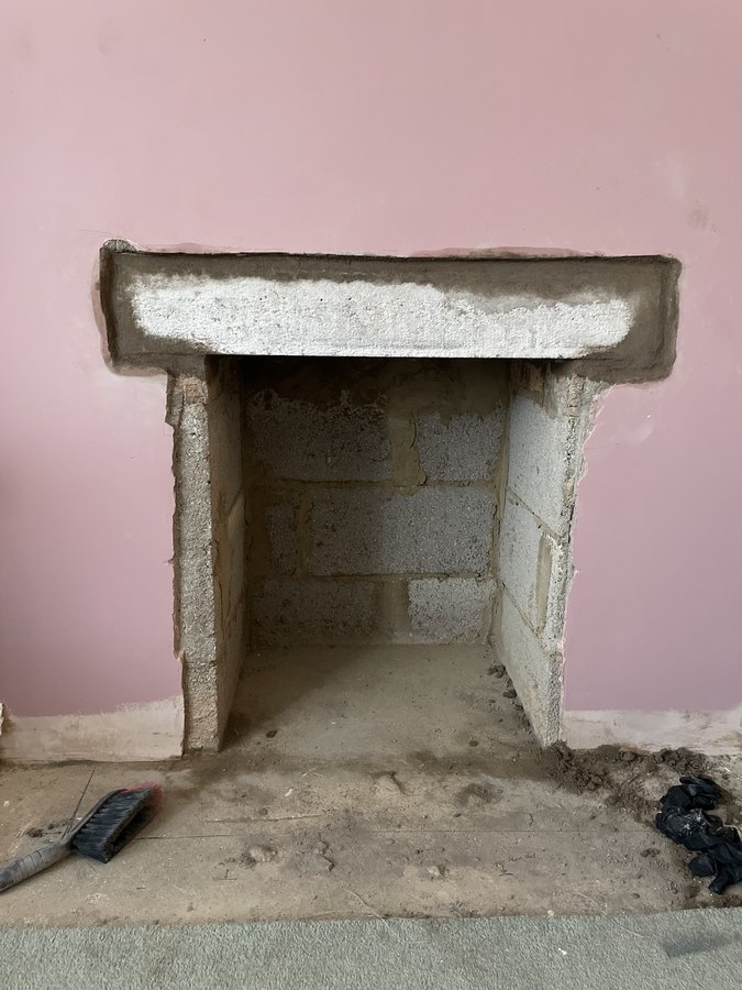 A new concrete lintel bedded in above a fireplace opening, packed and pointed