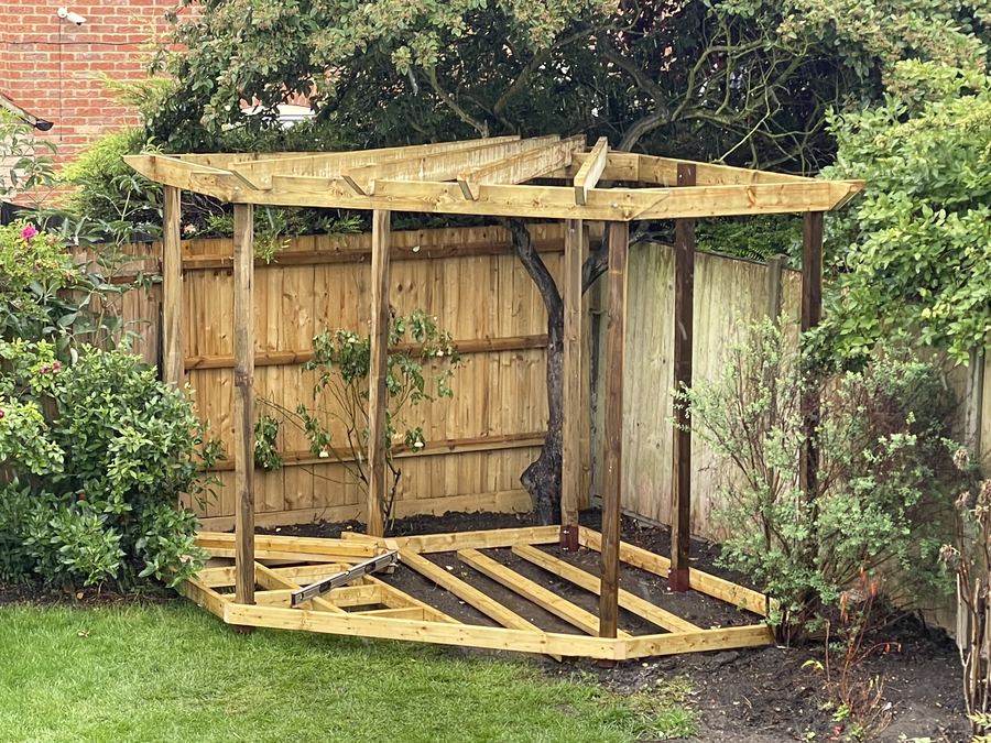A timber deck sub-frame built beneath a pergola, levelled ready for boards